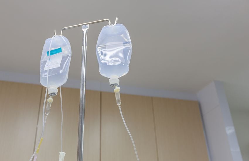 Iv Pole With Two Saline Bags Hanging From It.