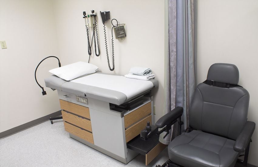 An Empty Exam Room With A Gynecological Table.