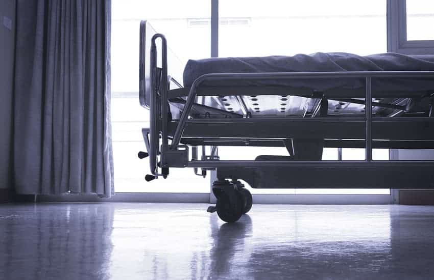The End Of A Hospital Bed Sitting In A Dark Hospital Room
